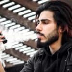 what is vaping in dubai - Portrait of a young man vaping outdoors in Dubai, showcasing modern lifestyle and fashion.